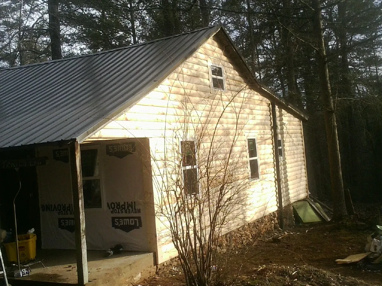 Log siding gable end under a dark metal roof edge in Keystone