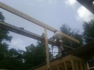 Carpenter setting a ridge beam over a new addition frame — Ice Dam Removal by Roofing Brothers in Keystone