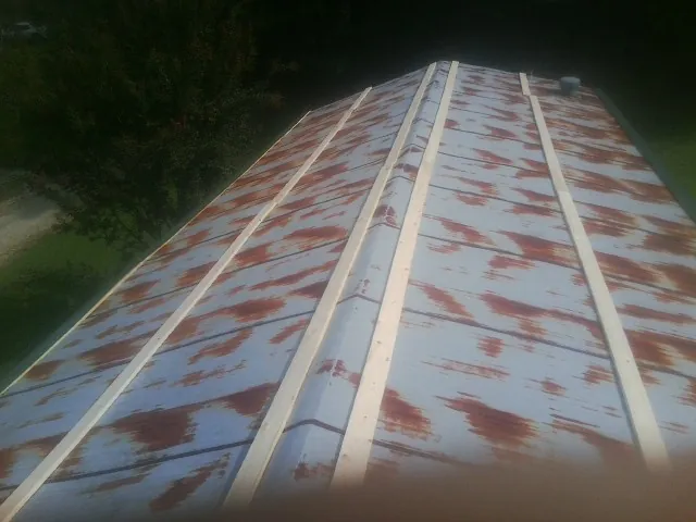 Rusted metal roof panels with new wood purlins before replacement — Storm Damage Roof Repair in Keystone by Roofing Brothers